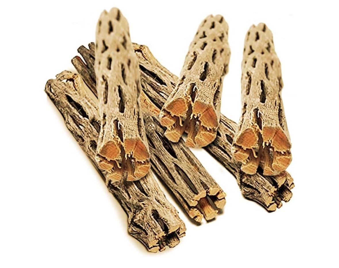 6 pieces of cholla wood stacked loosely on a white background. 
